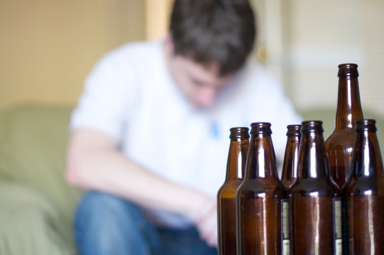 Man looks depressed with empty beer bottles